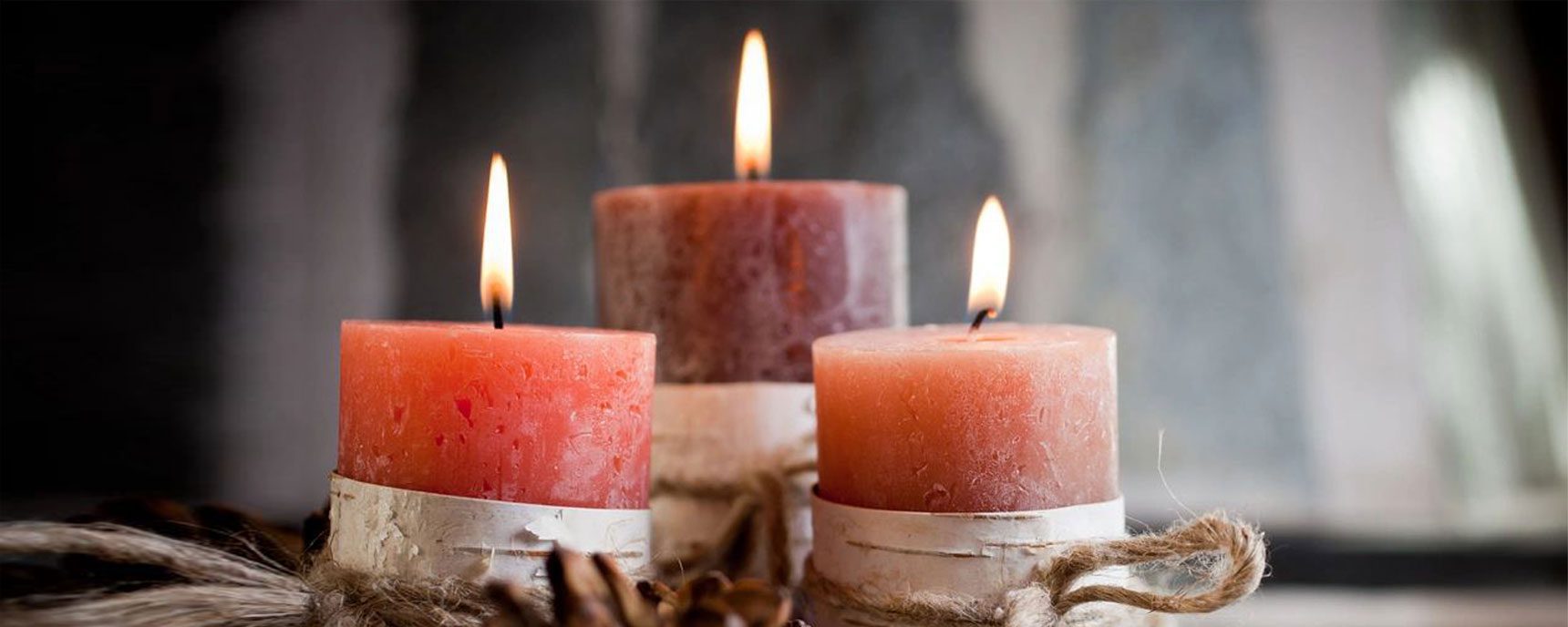 Three candles are lit on a table.