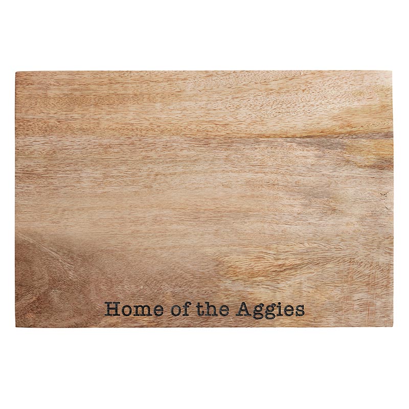 A wooden cutting board with the name of the aggies on it.