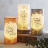 A group of three candles with the words " let your light shine ".