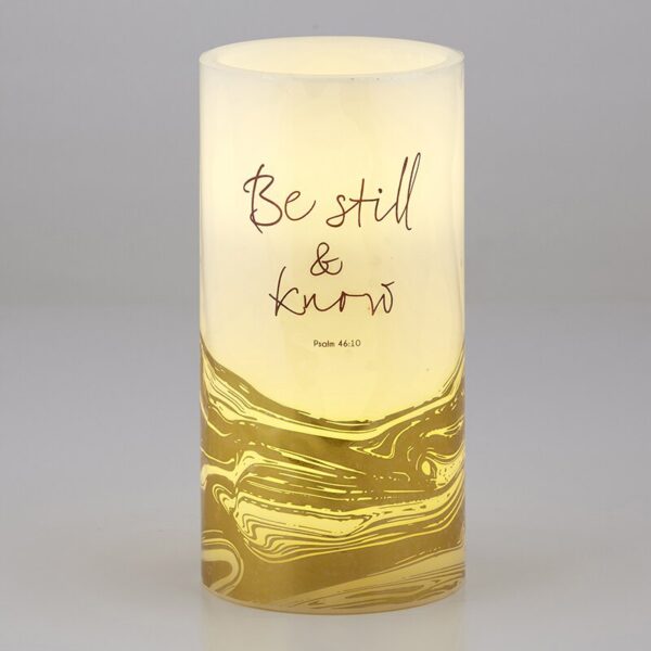 A candle that has the words " be still and know."