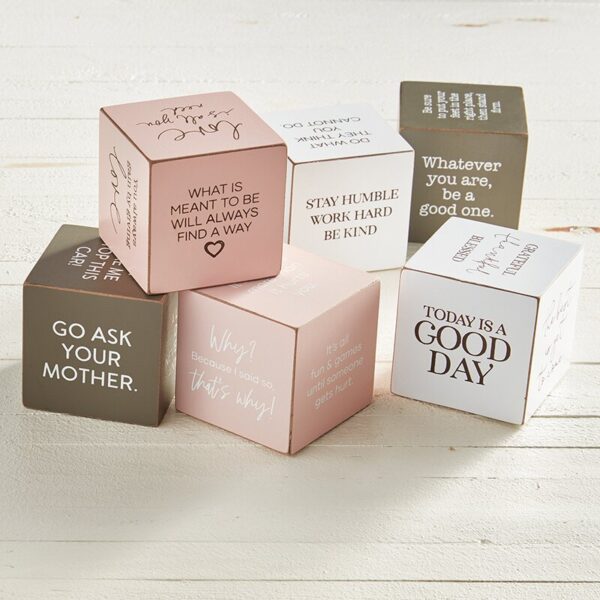 A set of six cubes with different sayings on them.