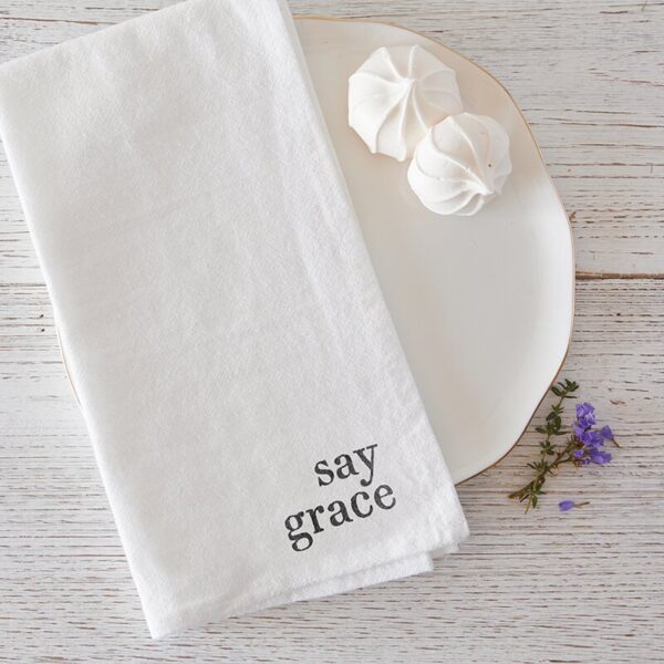 A white cloth napkin with the words " say grace ".