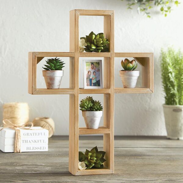 A cross shaped shelf with plants in it