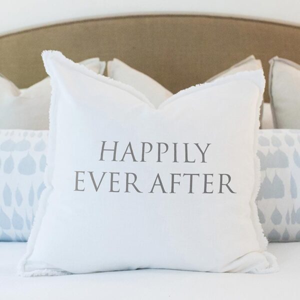 A white pillow with the words " happily ever after ".