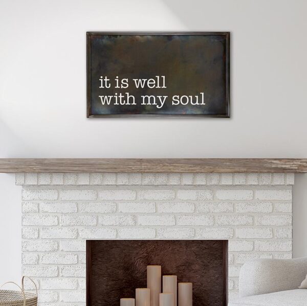 A fireplace with a sign hanging on the wall above it.