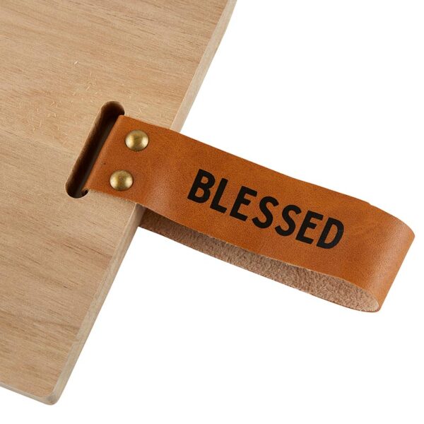 A wooden table with a leather strap that says " blessed ".