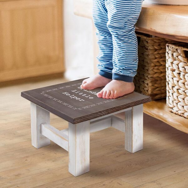 A child standing on top of a stool.