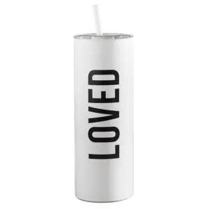 A white candle with the word " loved " written on it.