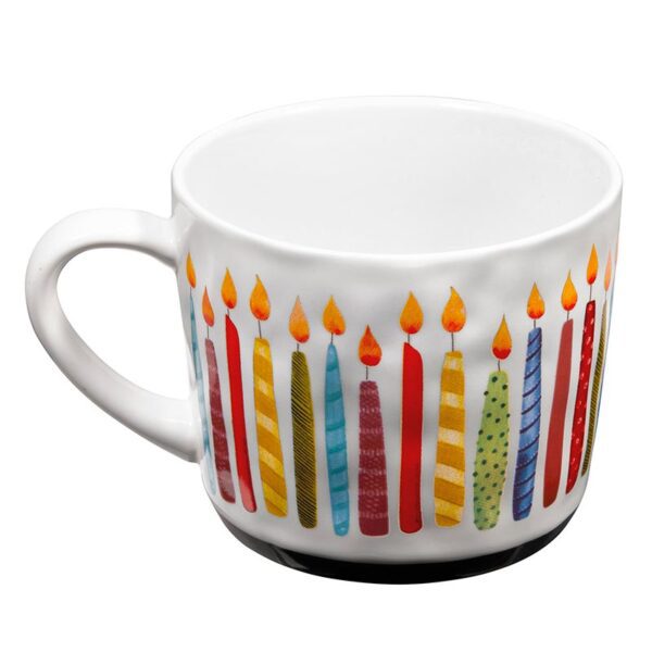 A white mug with candles on it.