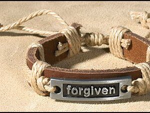 A leather bracelet with the word forgiven on it.