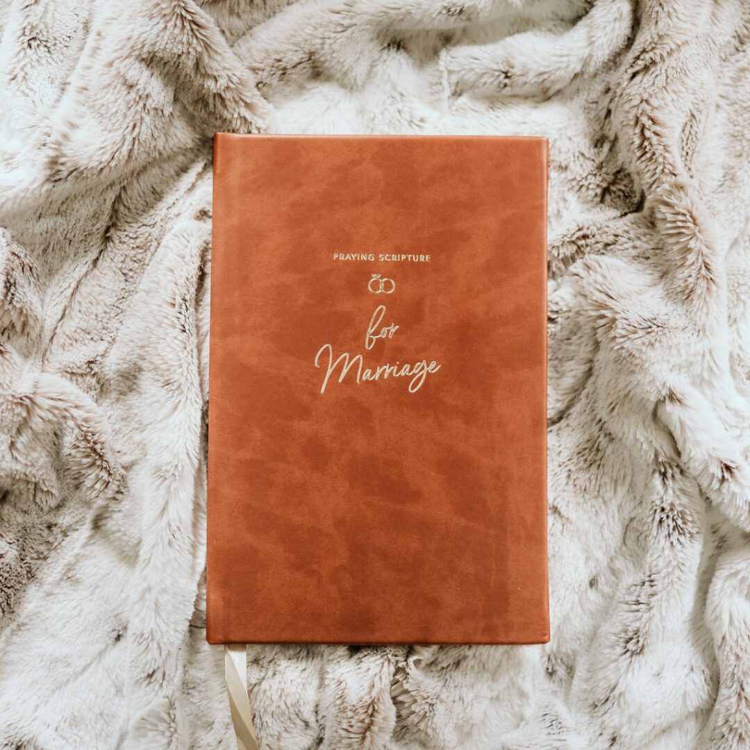 A brown book sitting on top of a blanket.