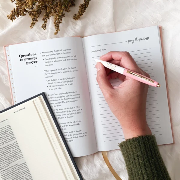 A person writing in a book on the bed