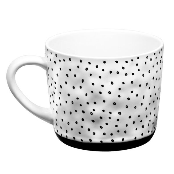 A white mug with black polka dots on it.