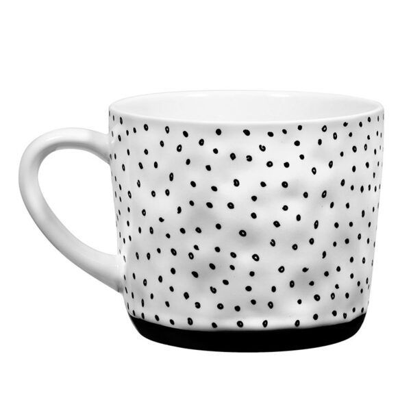 A white cup with black dots on it