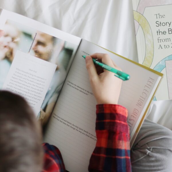 A child is writing in a book